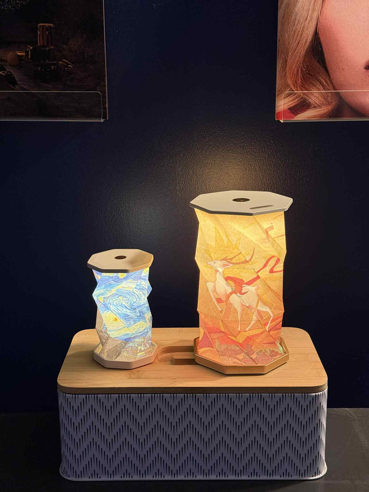 Petite et grande lanternes OrigaLux allumées côte à côte, avec deux motifs différents.